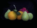 Still life. Pears, oranges and pomegranate on a black background Royalty Free Stock Photo