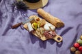 Picnic with cheese, bread, figs and sausage on lavender blanket Royalty Free Stock Photo