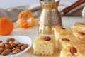 Still life Pieces Basbousa or namoora traditional arabic dessert. Semolina cake with almond nut and syrup, orange and cooper jezva