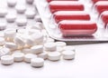 Still life with pile of round pills or tablets, antidepressants or painkillers with space for text. Red capsules in blister pack