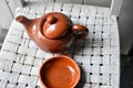 Still life of a plate and a pot of artisan clay placed on a gray chair