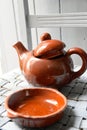 Still life of a plate and a pot of artisan clay placed on a gray chair