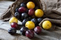 Still life with plums in a basket on the table