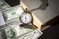 Still life of pocket watch on bills and old book Royalty Free Stock Photo