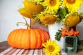 Still life with pumpkin, a bouquet of sunflowers and a white vase, candlesticks and red rowan, hello autumn concept Royalty Free Stock Photo