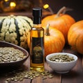 Still life with pumpkin seed oil in a glass carafe, pumpkin seeds and pumpkins as decortation on a wooden table