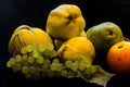 a still life with quinces, grapes, pears and apples and black background Royalty Free Stock Photo