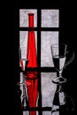 Still life with a red bottle and glasses with liquid on a window background Royalty Free Stock Photo