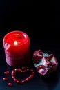 Still life with red candle and pomegranate heart. Concept romantic card.