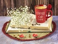 Still life with a red cup of coffee, books, gypsophila flowers and coffee beans Royalty Free Stock Photo