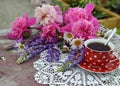 Still life with red cup of tea and beautiful bunch of peony and lupin flowers Royalty Free Stock Photo