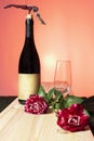 Still life of red wine bottle and glass with red roses with warm sunset background