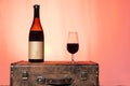 still life of red wine bottle and glass with warm sunset background