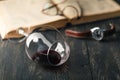 Still life with red wine and old books on the old wooden table in retro style Royalty Free Stock Photo