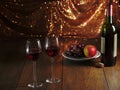Still life with red wine theme, Two glasses in focus, Plate with fresh grapes and apple, Bottle and cork on a wooden table, warm