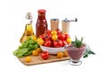 Still life of red and yellow tomatoes, bottle of tomato sauce and olive oil on white background.