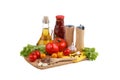 Still life of red and yellow tomatoes, bottle of tomato sauce and olive oil on white background.