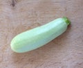 Still life with ripe green zucchini lying on a wooden surface