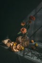 Still life with ripe pears and autumn flowers on a dark rustic background in a sunlights Royalty Free Stock Photo