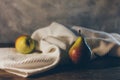 Ripe yellow with red tasty pears on the waffled white towel on the rustic dark brown wooden table and concrete grey bac