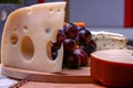 Still life Roquefort, swees cheese and red grapes on wooden plate Royalty Free Stock Photo