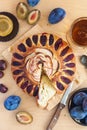 round plum cake, cut into pieces, decorated with a rose from apple slices, a cup of black tea and a saucer with fruit