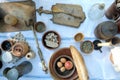 Rural meal of antique utensils, vintage scales and simple rustic foods on a white tablecloth outdoors, top view