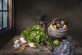 Still life in a rustic kitchen with vegetables and a basket of pansies Royalty Free Stock Photo
