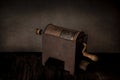Still life with rustic rusty coffee roaster on vintage grunge background. Side view, cross light