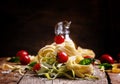 Still life in rustic style. Nest of pasta with cherry tomatoes, Royalty Free Stock Photo