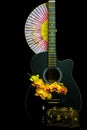 Still life scene with guitar, orchids and paper fan Royalty Free Stock Photo