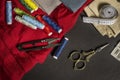 Still life with seamstress objects with golden vintage scissors, rolled measuring tape, various spools of thread, needles, Royalty Free Stock Photo