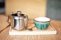 Still life set with cup of tea, teapot and tray on a wooden table in cafe interior Royalty Free Stock Photo