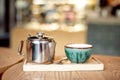 Still life set with cup of tea, teapot and tray on a wooden table in cafe interior Royalty Free Stock Photo