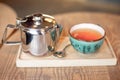 Still life set with cup of tea, teapot and tray on a wooden table in cafe interior Royalty Free Stock Photo