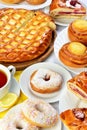 Still life of setout table with baking pies, donuts and tee cup Royalty Free Stock Photo