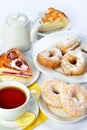 Still life of setout table with baking pies, donuts, tee cup and Royalty Free Stock Photo