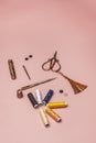 Still life of sewing kits with spools of colored threads, items and vintage copper scissors on a plain pink background Royalty Free Stock Photo