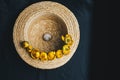 Bouquet of yellow waterlily flower with green leaf. freshly ripped up. In a straw hat. close up on black background of fabric. Royalty Free Stock Photo