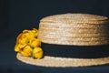 Bouquet of yellow waterlily flower with green leaf. freshly ripped up. In a straw hat. close up on black background of fabric. Royalty Free Stock Photo