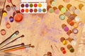 Still life, showing an interest in watercolor painting and art. A lot of brushes, jars with watercolor paint and used gouache lie Royalty Free Stock Photo