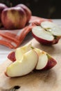 still life, slices of red chopped apple, on a wooden board on a white table