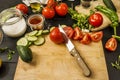 A still life with some ripe split tomatoes together with garlic, cucumber Royalty Free Stock Photo