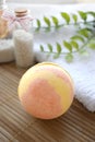 Still life spa resort treatment with bath bomb and towel on wooden background.