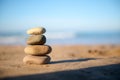 Still life with stacked pebbles, stones on the sandy beach against the background of Atlantic ocean with breaking waves Royalty Free Stock Photo