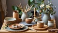 Still life. A styled table of pots, vases, plates and ceramic and wooden decor items