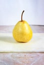 Still life with a sweet ripe pear on a light table Royalty Free Stock Photo