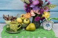 Autumn still life with fruits, flowers, herbs, a cup of tea and a clock. Royalty Free Stock Photo