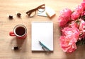 Still life on a table made of light wood. A white Notepad, a Cup of tea,, flowers. Royalty Free Stock Photo