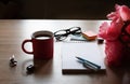 Still life on a table made of light wood. A white Notepad, a Cup of tea,, flowers. Royalty Free Stock Photo